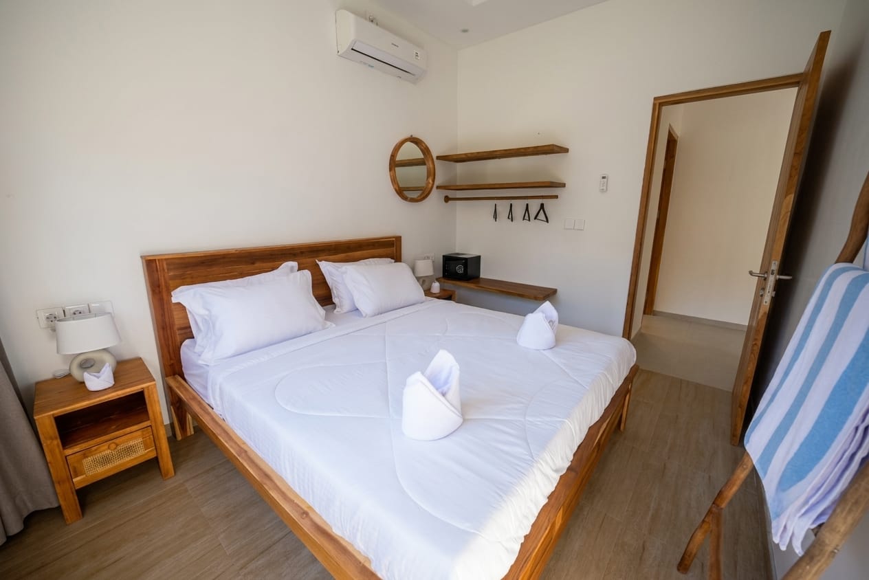 Second bedroom with teak headboard and wardrobe corner
