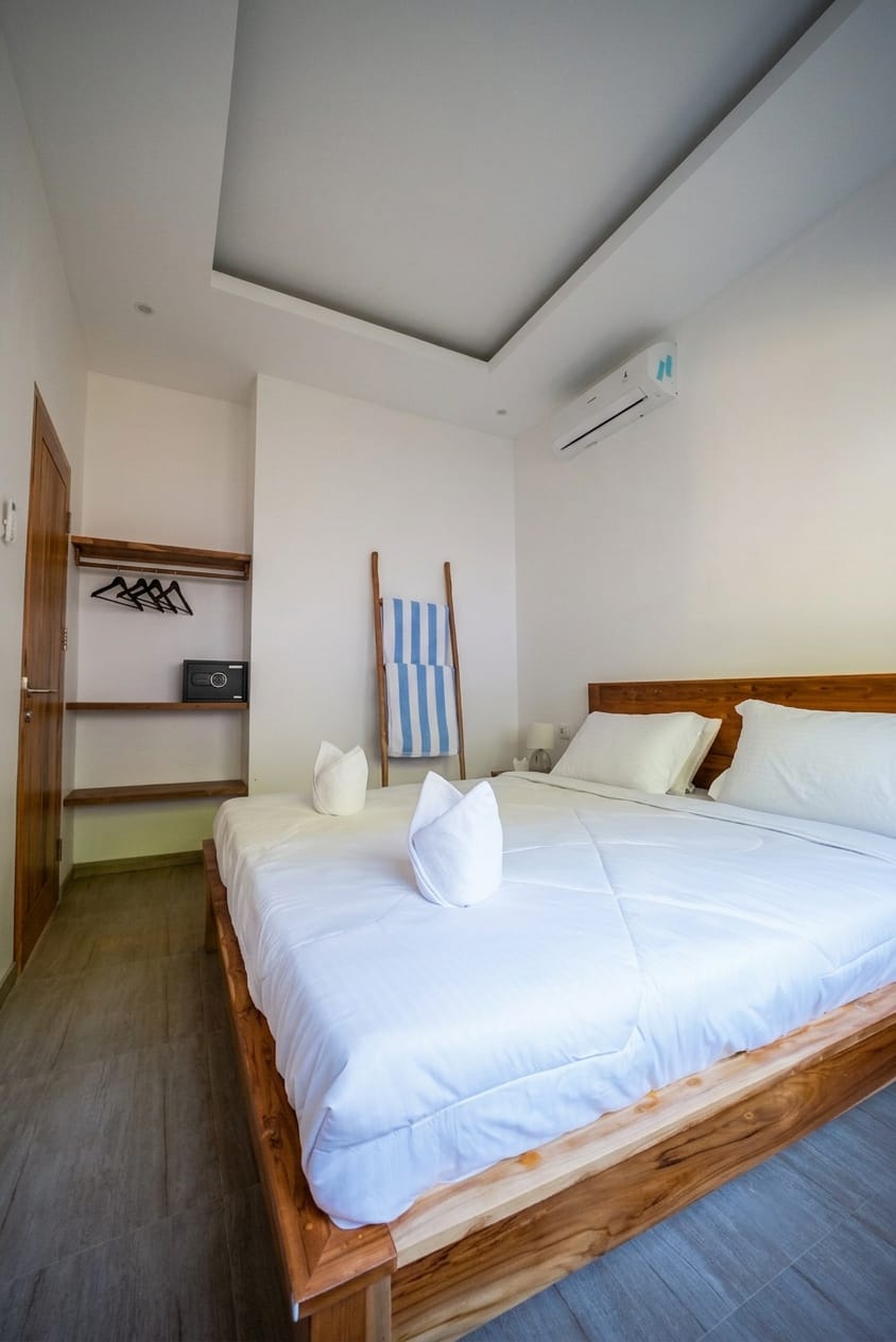 Master bedroom with teak bed frame and recessed ceiling