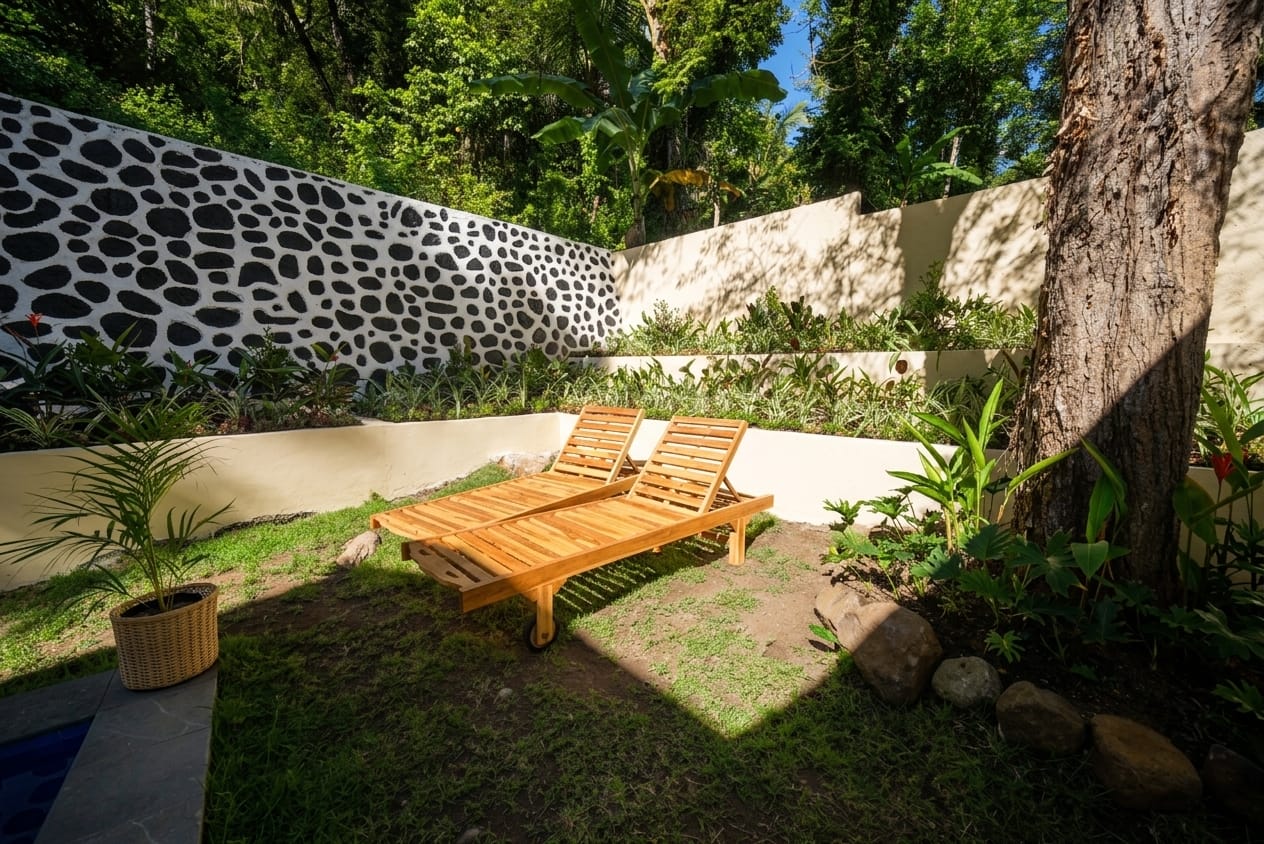 Tropical garden with teak sun loungers and stone-accent wall