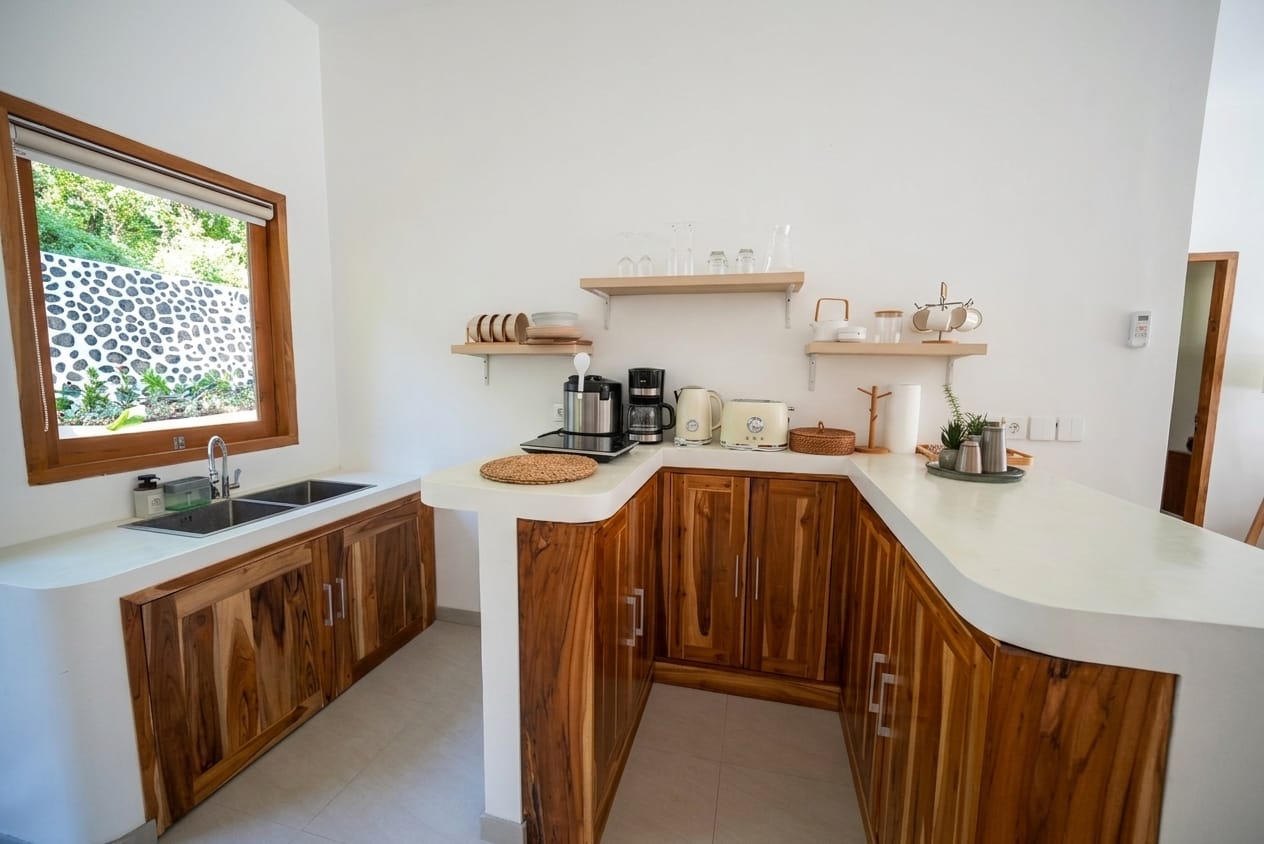Fully equipped kitchen with teak cabinetry and white stone counters