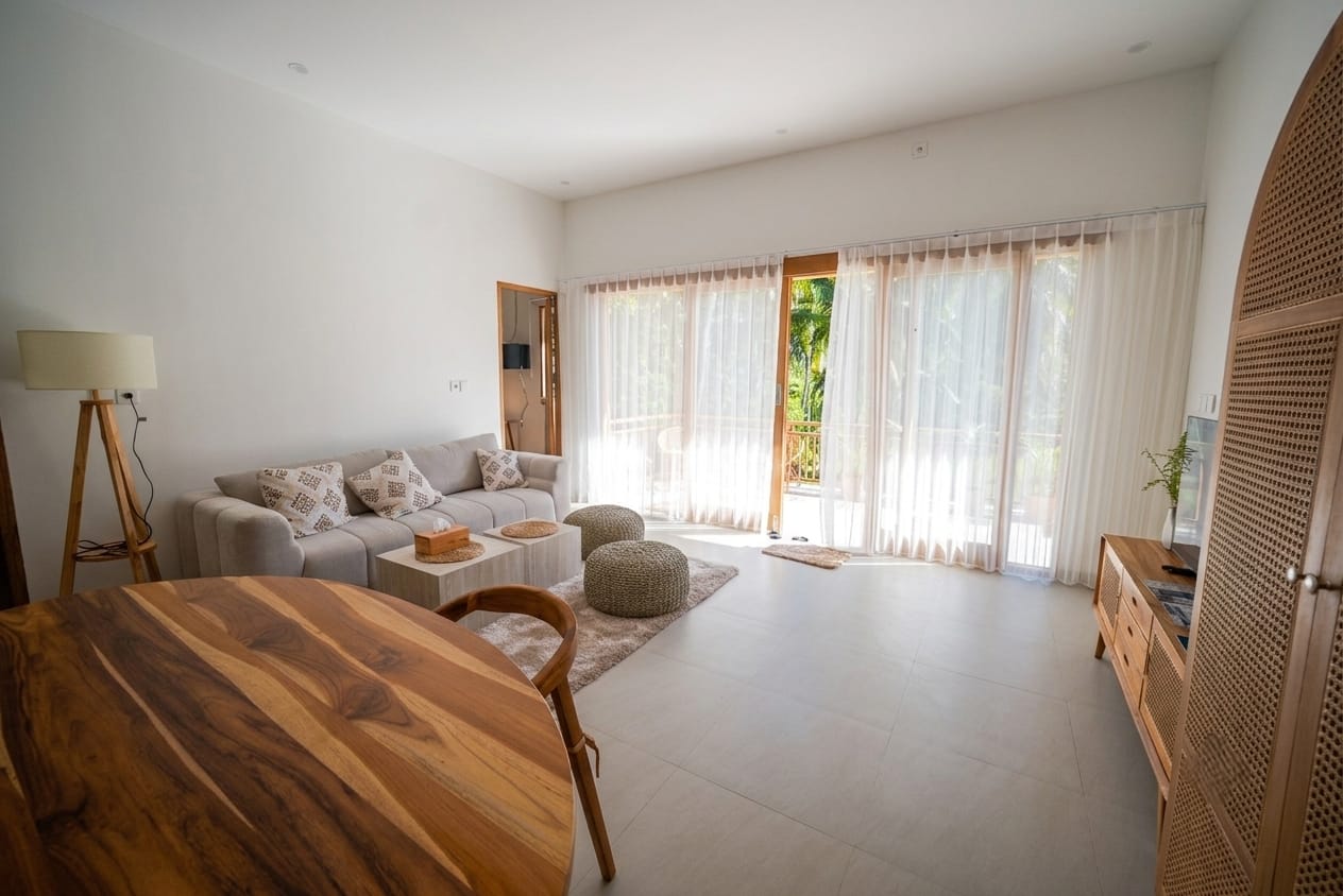 Living room with sheer curtains opening onto the terrace