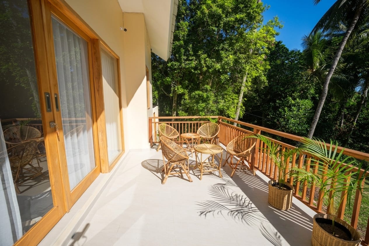 Covered terrace with rattan lounge chairs overlooking the jungle