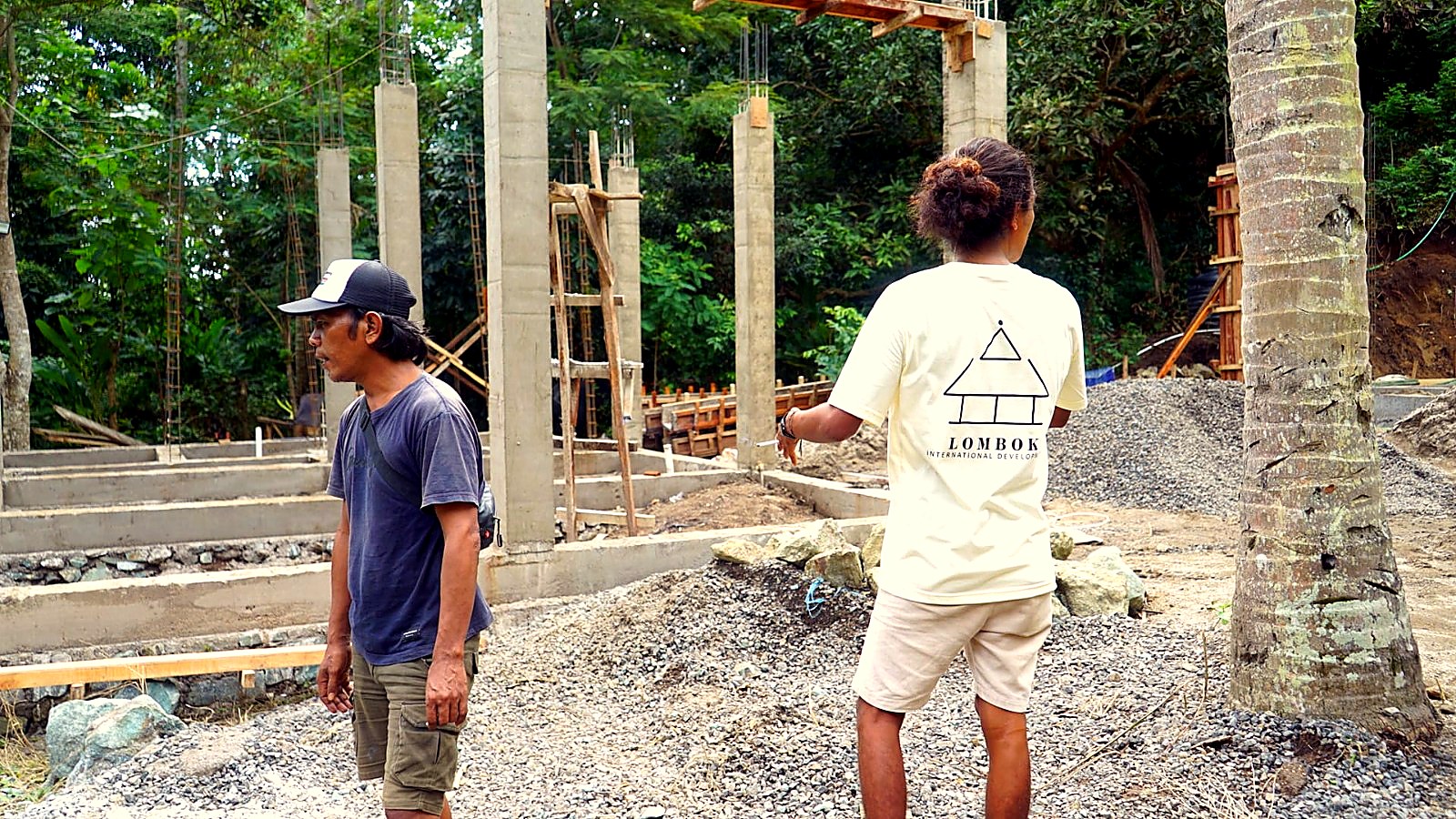 Two crew members supervising concrete columns during the foundation stage