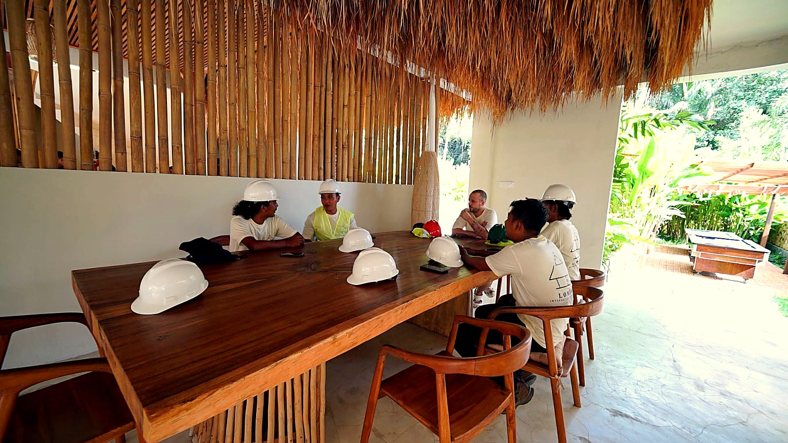 Crew meeting with white helmets around the solid timber table