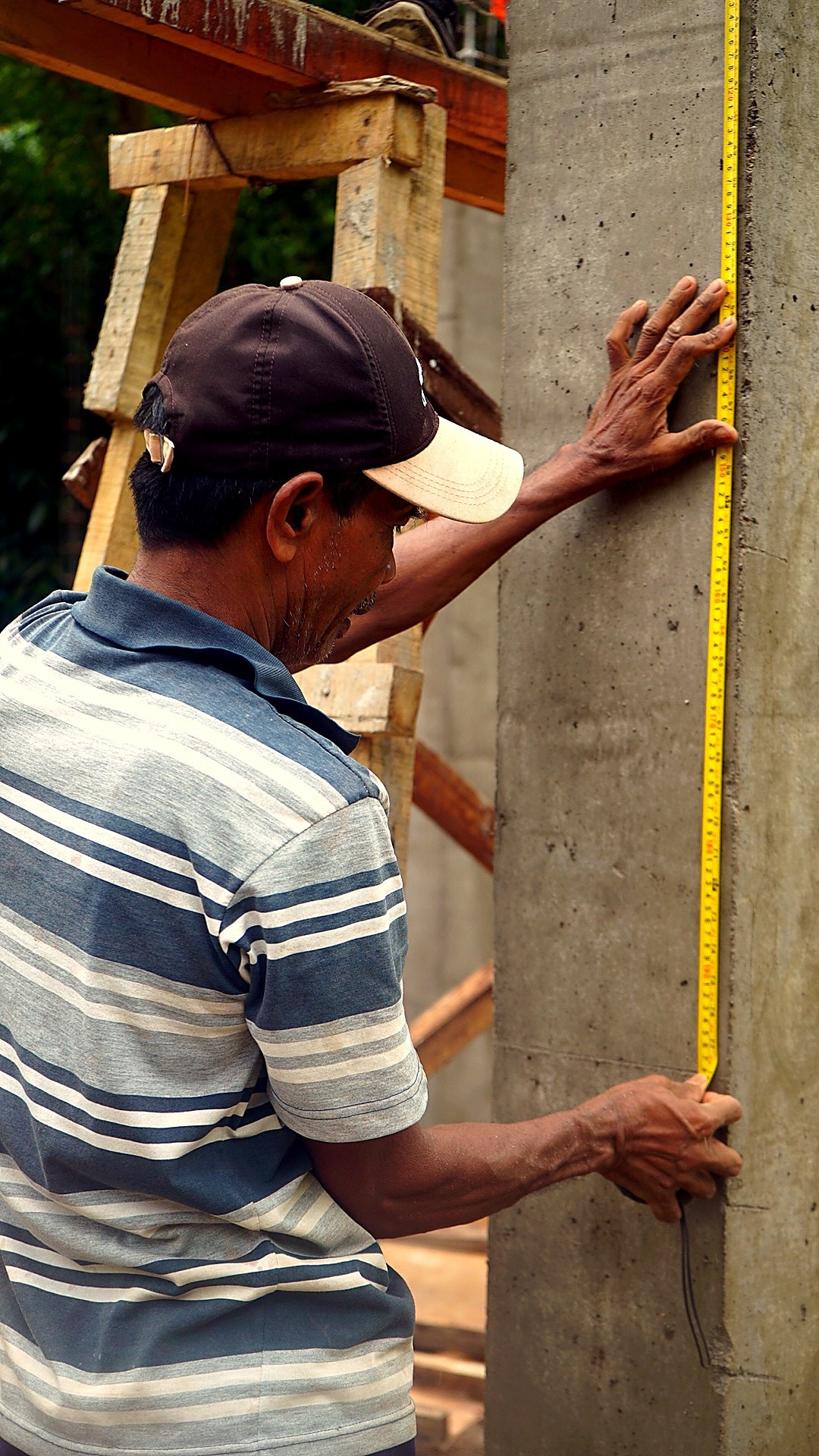 Detail of the team measuring a freshly cast concrete surface with a tape
